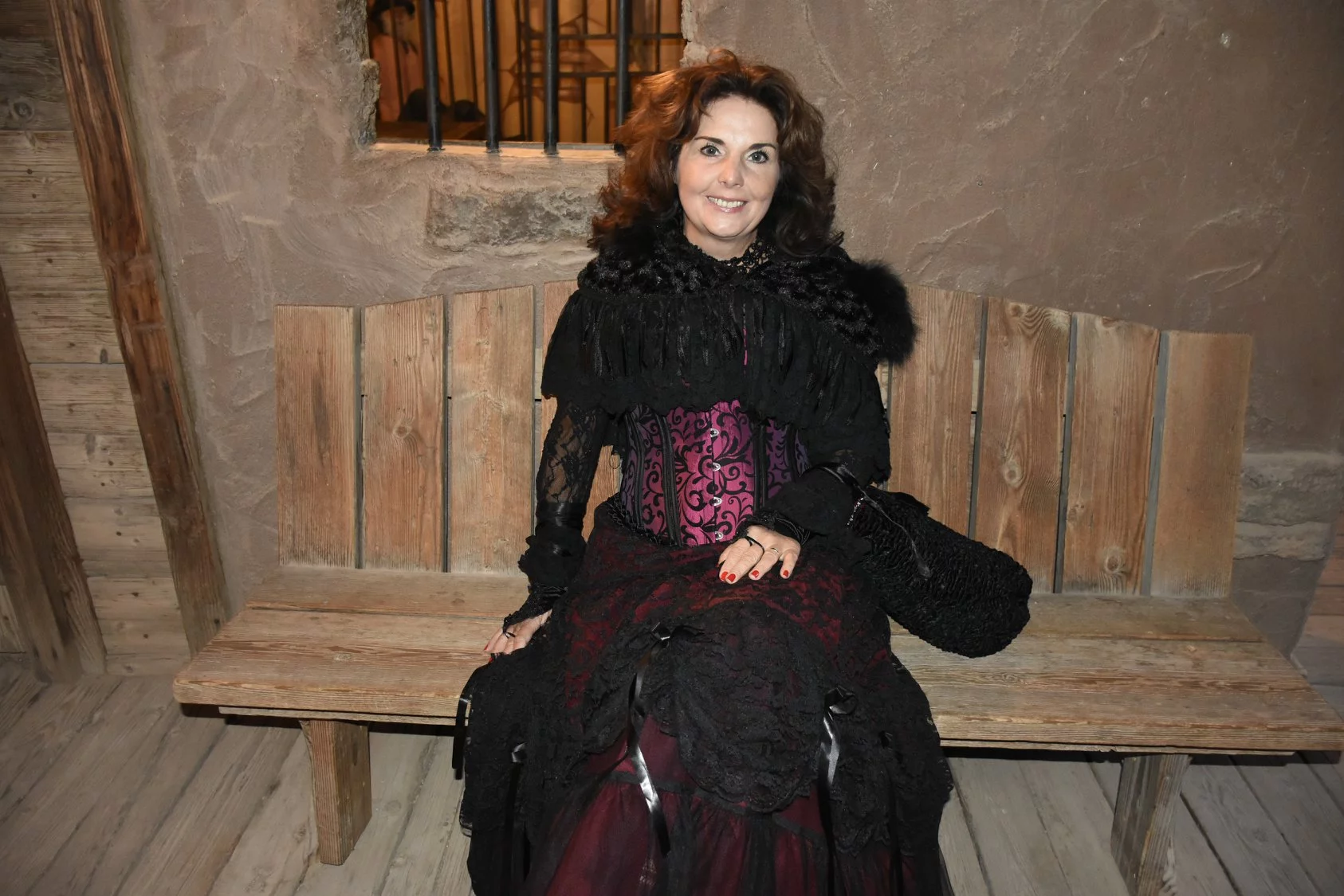 Manuela Schneider Sits On Old Wooden Bench While In Costume